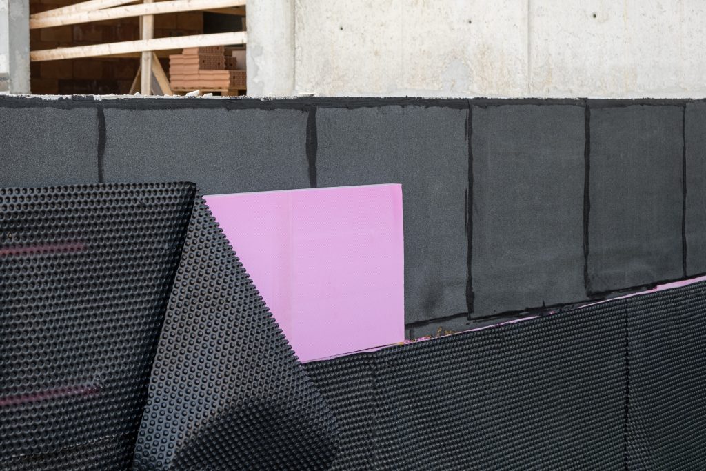 waterproof and ground thermal insulation coatings applied on the Foundation bottom wall in a new house under construction. PVC membrane building insulation and example Bitumen material